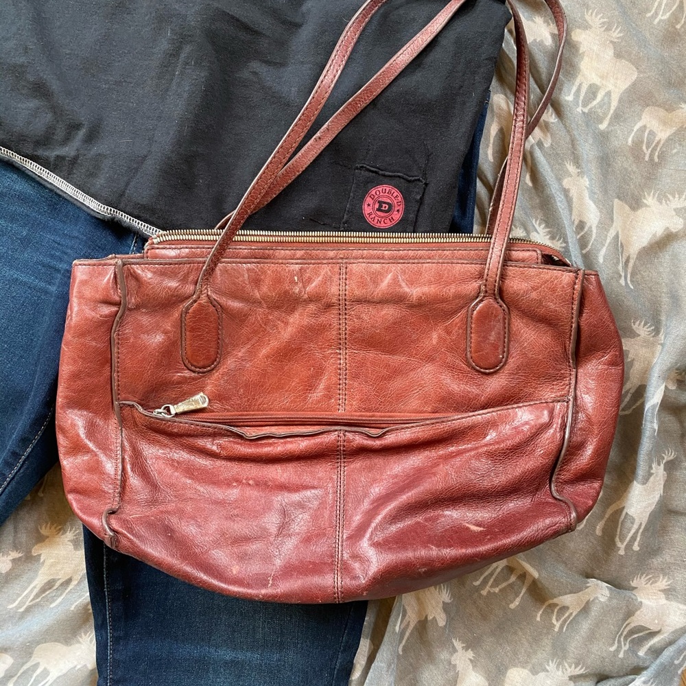 Burgundy leather bag with zipper closure and floral print interior